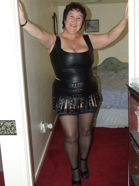 20P Amadora madura Kinky Carol remove a roupa de couro para ficar nua em meias