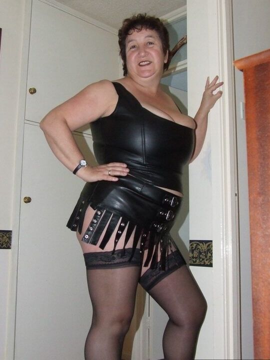 20P Amadora madura Kinky Carol remove a roupa de couro para ficar nua em meias