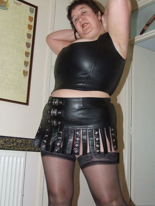 20P Amadora madura Kinky Carol remove a roupa de couro para ficar nua em meias