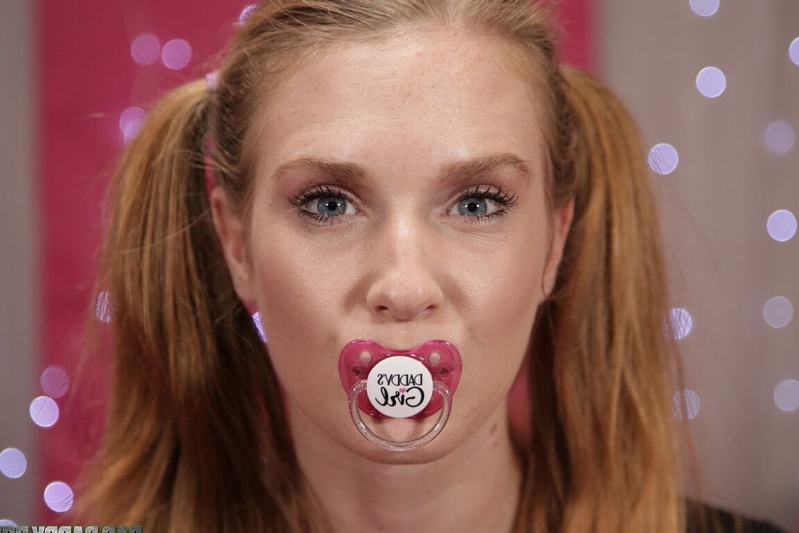 21P Redhead teen Ashley Lane sucks on a plastic nipple while posing in panties