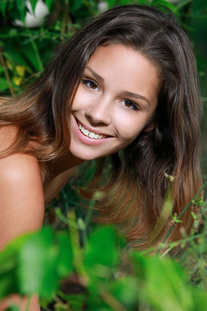 16P Cute teen Arina F showcases her bald twat after getting naked afore greenery