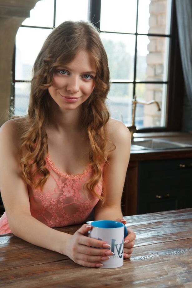 16P A linda jovem Siya fica nua na mesa da cozinha tomando uma xícara de café