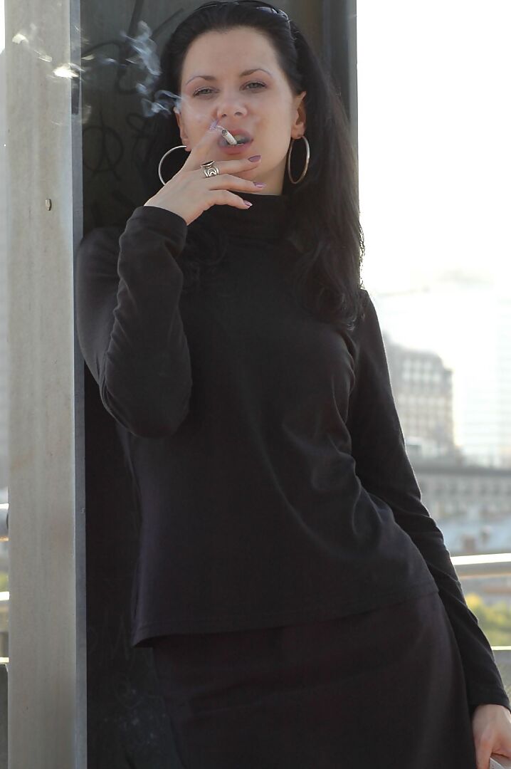 16P Fully clothed brunette lights up a cigarette with her sunglasses atop her head