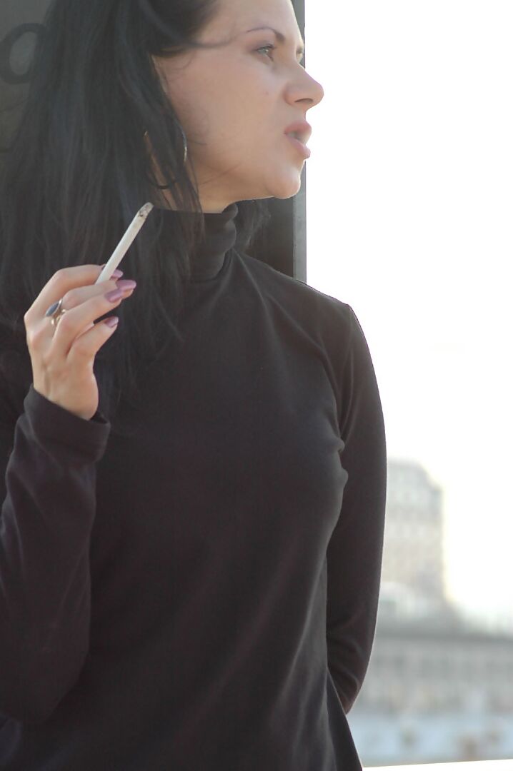 16P Fully clothed brunette lights up a cigarette with her sunglasses atop her head