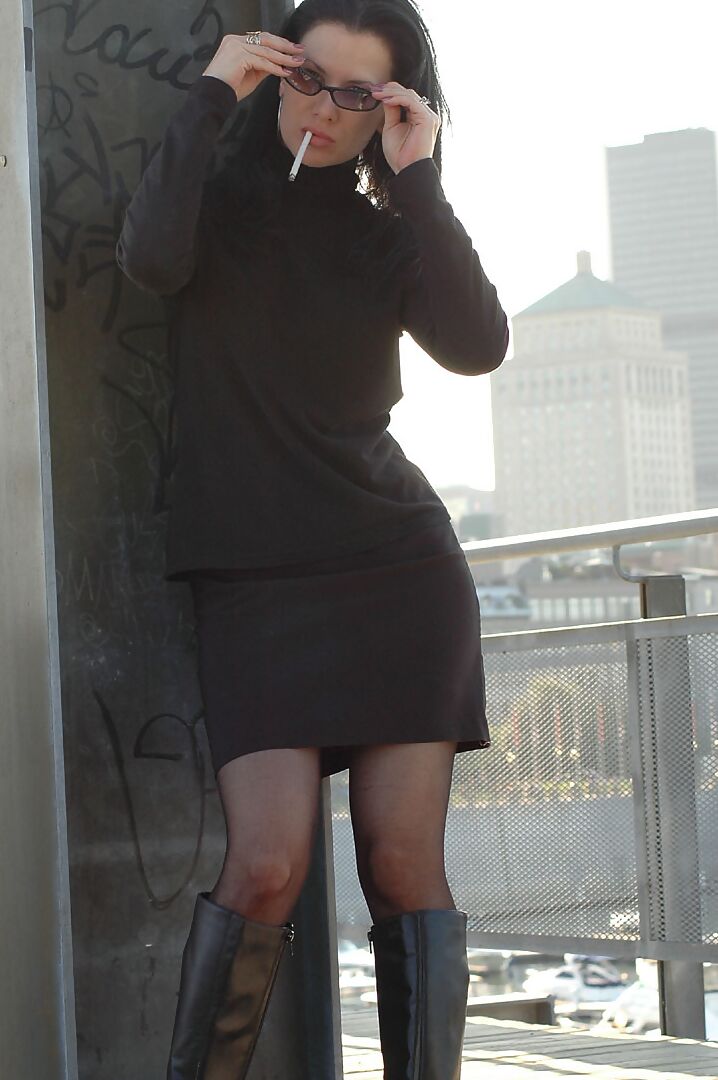 16P Fully clothed brunette lights up a cigarette with her sunglasses atop her head