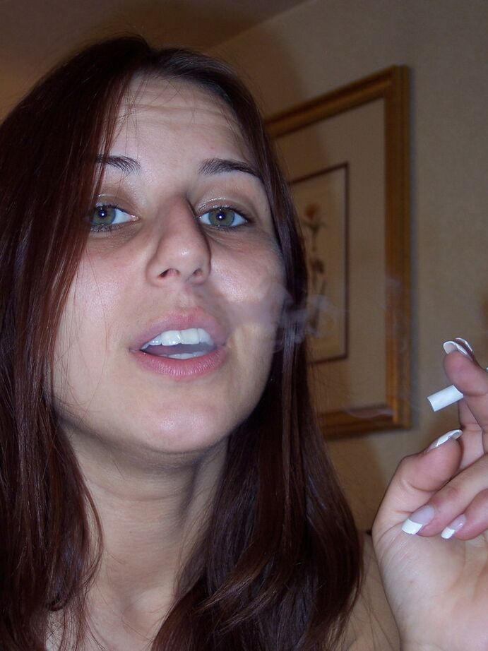 20P La chica totalmente desnuda Lexxxi se sienta en su cama mientras fuma un cigarrillo