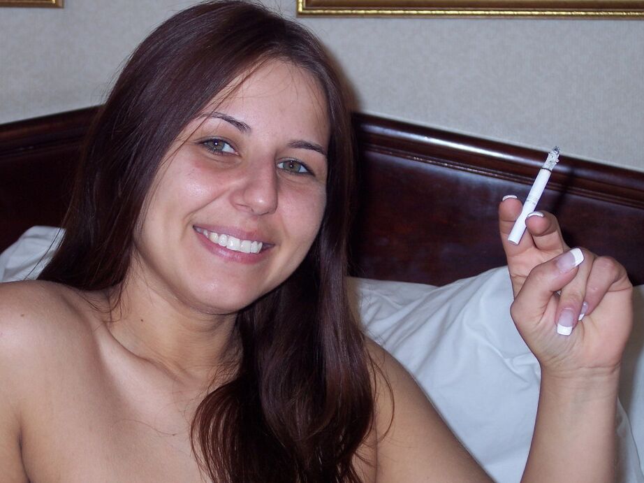20P La chica totalmente desnuda Lexxxi se sienta en su cama mientras fuma un cigarrillo