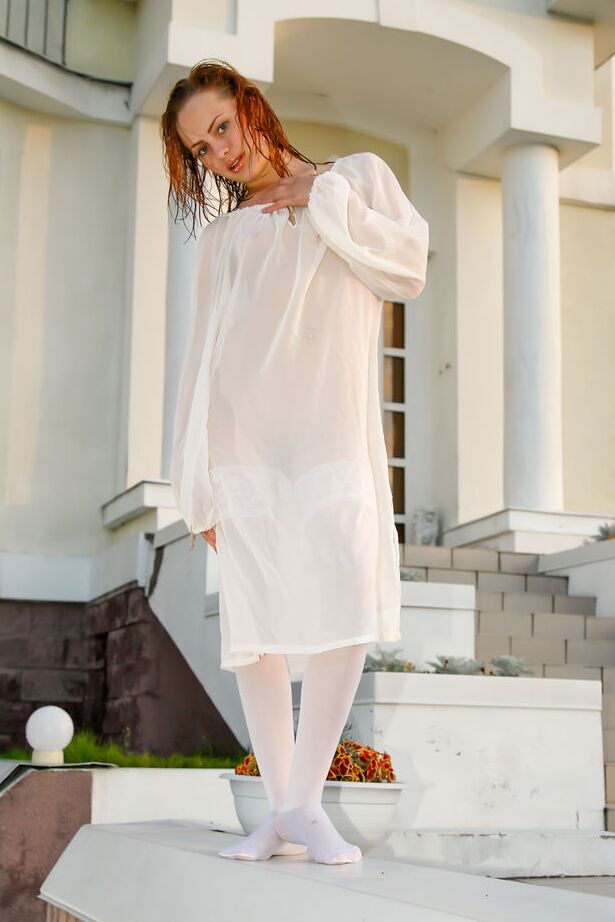 16P Barely legal redhead Alisabelle poses nude in white stockings outside a house