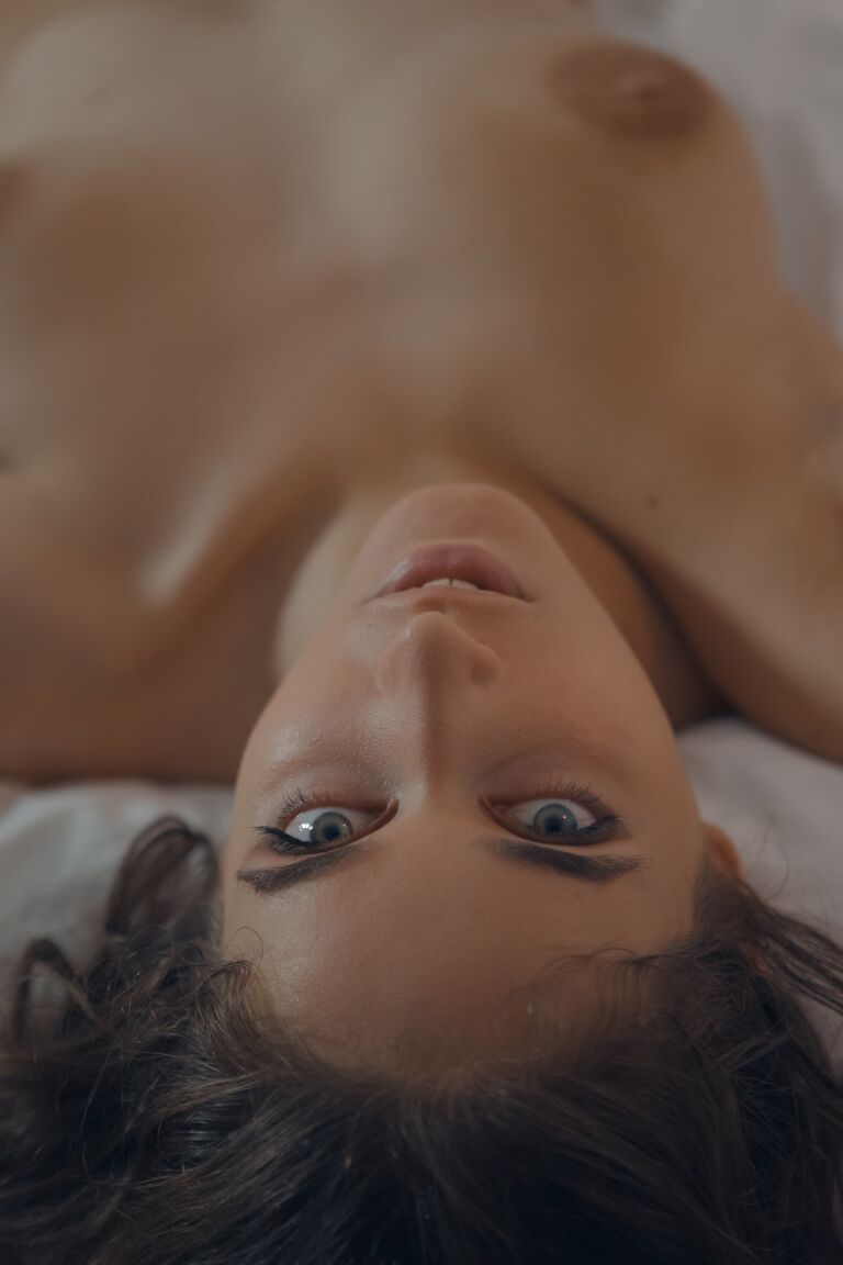 21P La adolescente caliente Emily J se tumba en la cama exponiendo su atractivo coño peludo