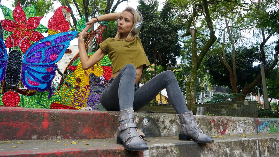 16P Verónica Leal posando sobre toda su capucha con camisa verde y jeans ajustados