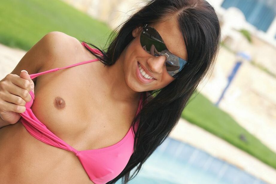 14P Morena esbelta se mete un par de dedos en su coño caliente junto a la piscina