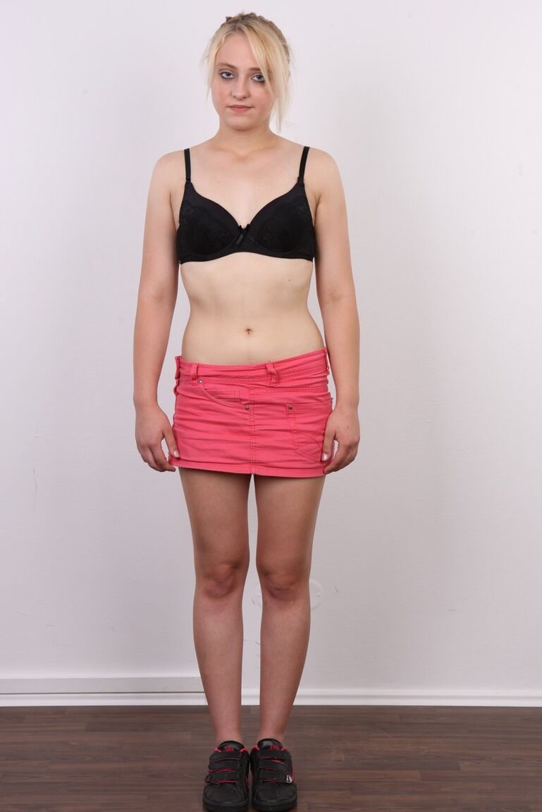 15P Die blonde Teenagerin Irena zieht ihre Kleidung aus, bevor sie nackt auf einem Hocker sitzt