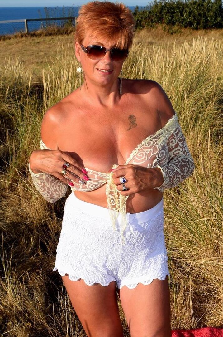 16P Mature redhead Dimonty exposes her sagging tits on a bench down by the sea
