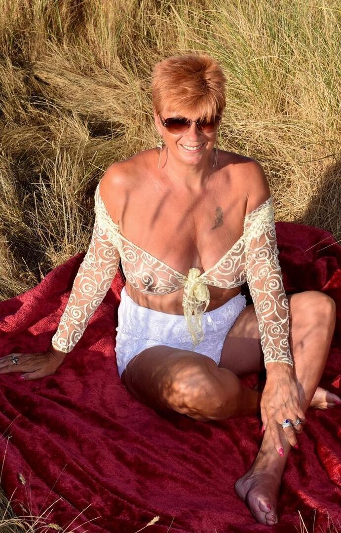 16P Mature redhead Dimonty exposes her sagging tits on a bench down by the sea
