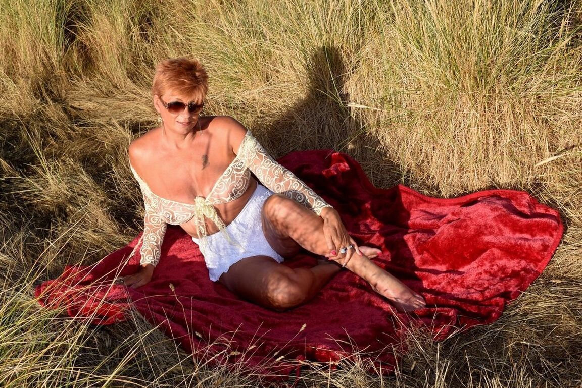 16P Mature redhead Dimonty exposes her sagging tits on a bench down by the sea