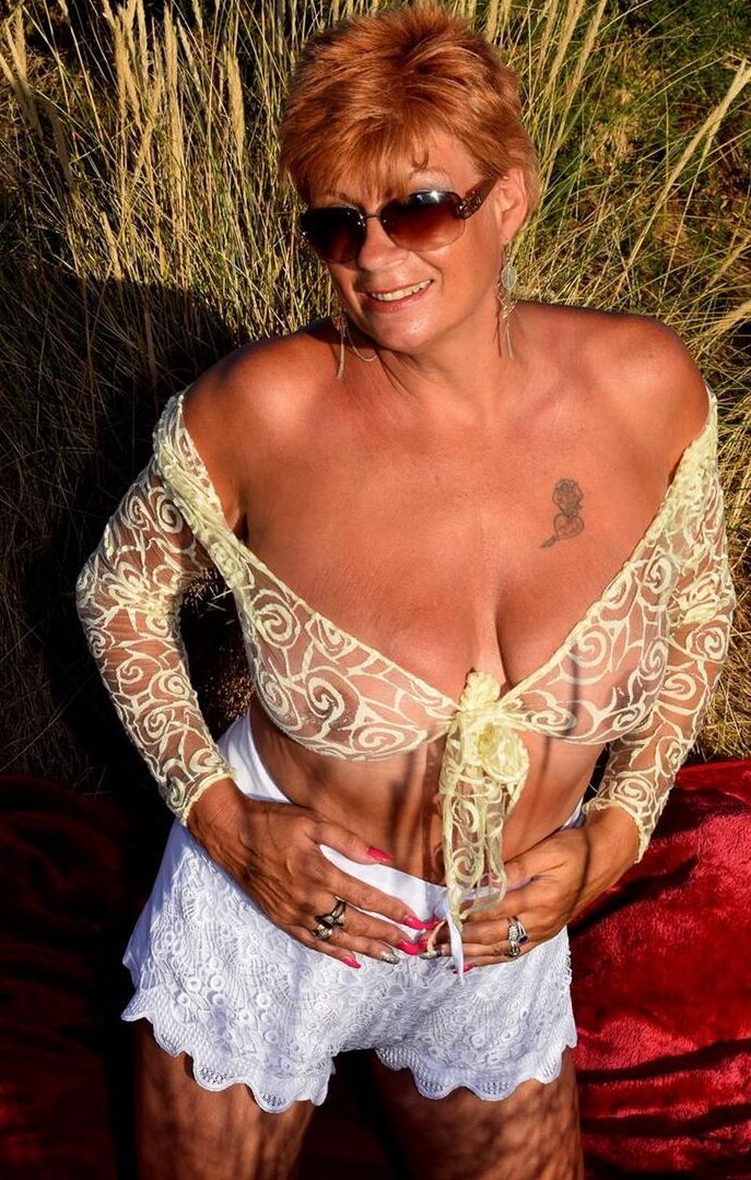 16P Mature redhead Dimonty exposes her sagging tits on a bench down by the sea