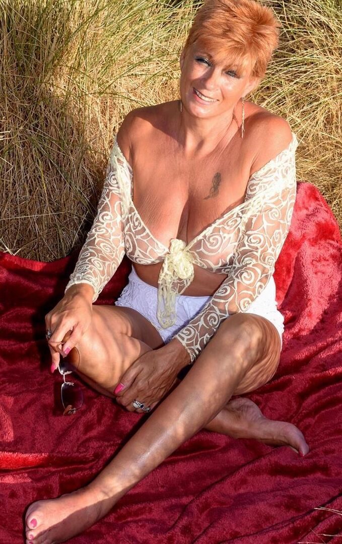 16P Mature redhead Dimonty exposes her sagging tits on a bench down by the sea