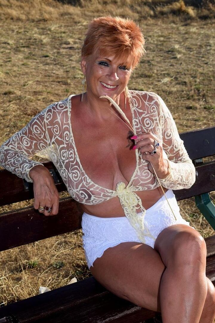 16P Mature redhead Dimonty exposes her sagging tits on a bench down by the sea