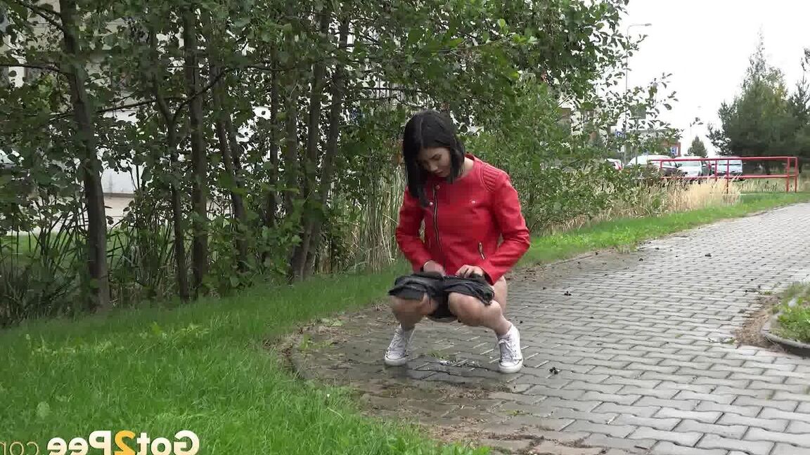 15P Garota de cabelos escuros é pega mijando em um caminho de tijolos ao ar livre