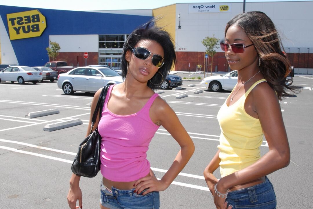 17P As mulheres negras Heidi Waters e Bella Moretta passeiam por um estacionamento