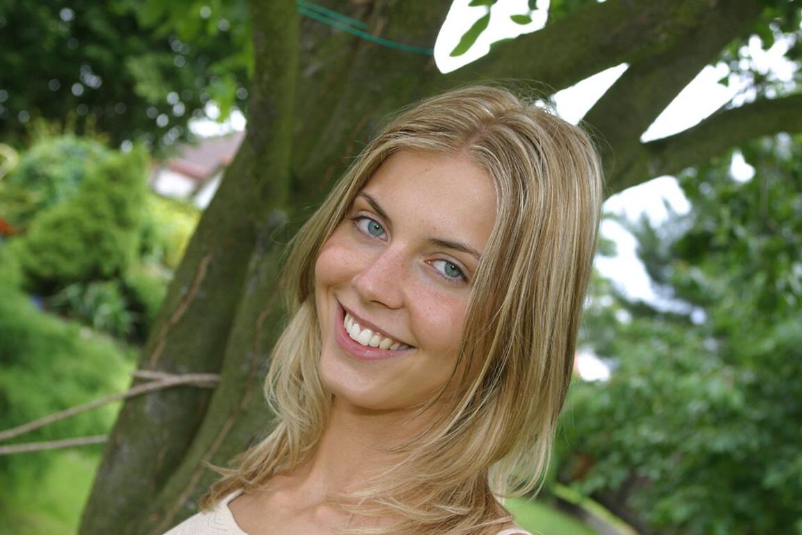 Sharon M, une adolescente souriante de 15P, laisse tomber son string de bikini pour écarter ses fesses à genoux sur la pelouse.