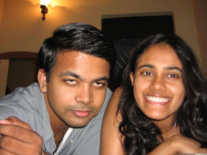10P Indian girl with a nice smile shows her breasts on top of a bed
