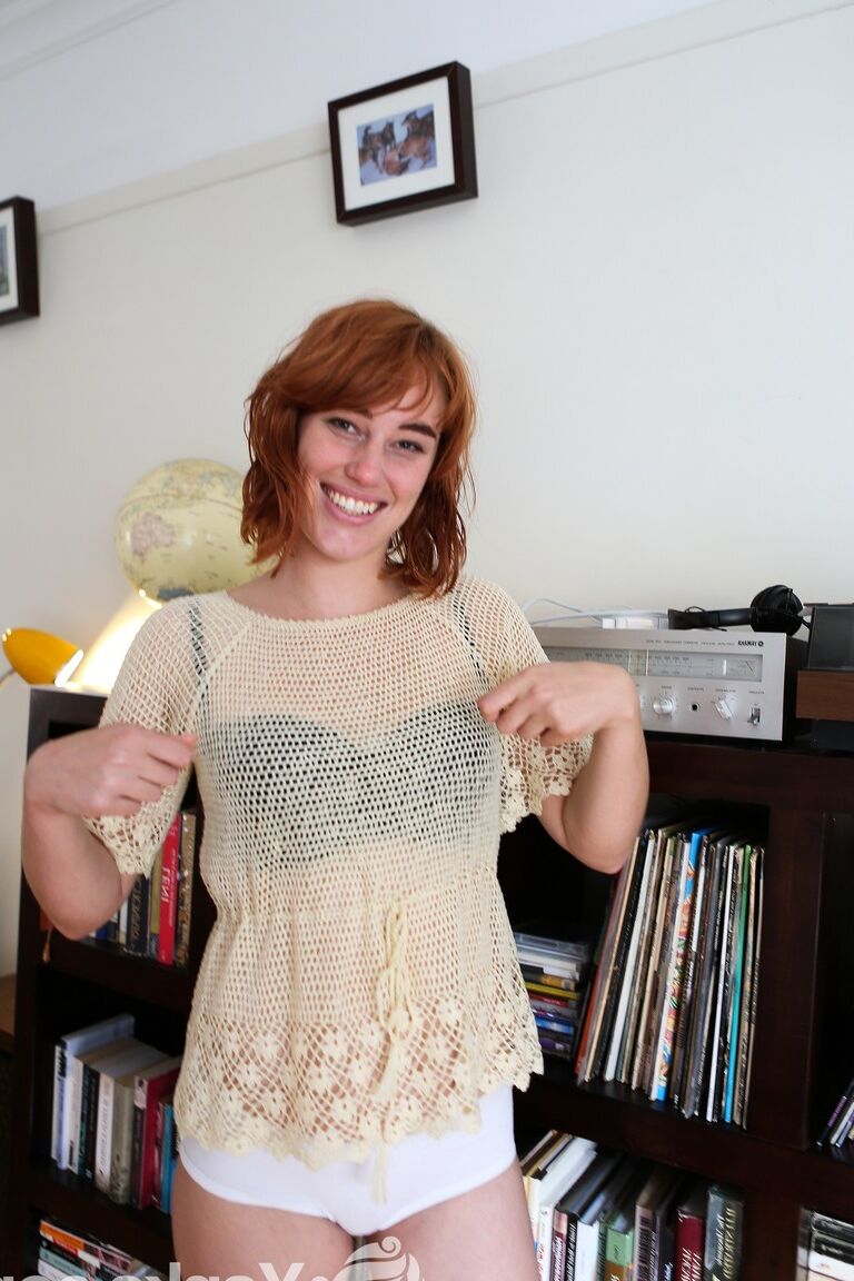 17P Pale redhead Molly Broad strips by the bookcase to flaunt her hairy muff