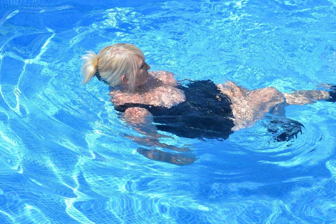 20P Thick blonde Melody displays her ample cleavage while fully clothed in a pool
