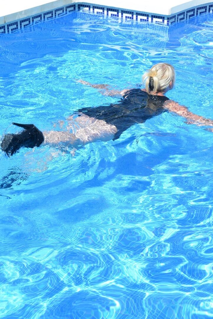20P Thick blonde Melody displays her ample cleavage while fully clothed in a pool