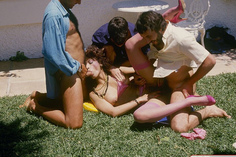 11P A estrela pornográfica da era dos anos setenta usa esperma no rosto depois de fazer sexo com dois caras na grama