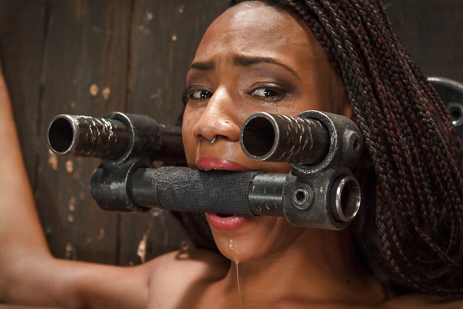 16P Black submissive Nikki Darling struggles against restraints in BDSM shoot