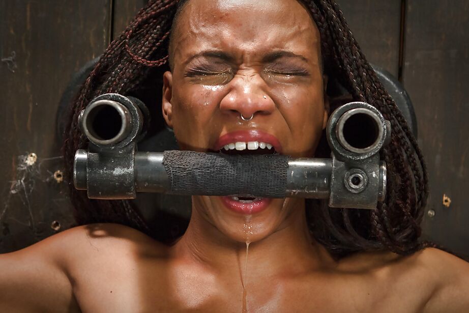 16P Black submissive Nikki Darling struggles against restraints in BDSM shoot