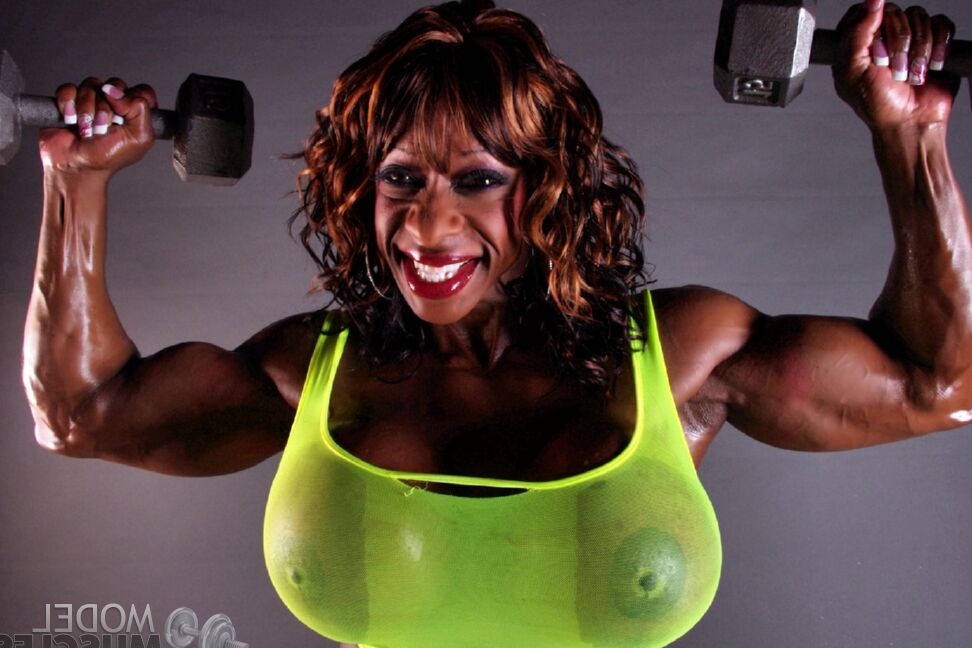17P Muscular ebony Yvette Bova lifting weights while flaunting her huge melons