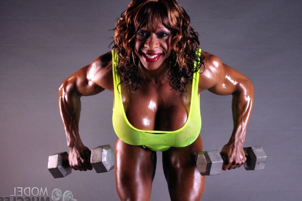17P Muscular ebony Yvette Bova lifting weights while flaunting her huge melons