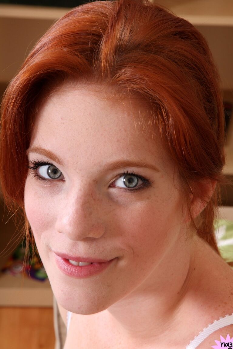 21P Attractive redhead with freckles Roxy Rush reveals her body on a couch