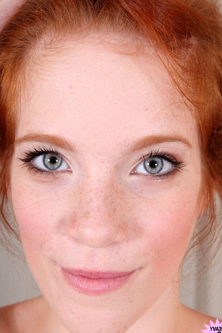 21P Attractive redhead with freckles Roxy Rush reveals her body on a couch