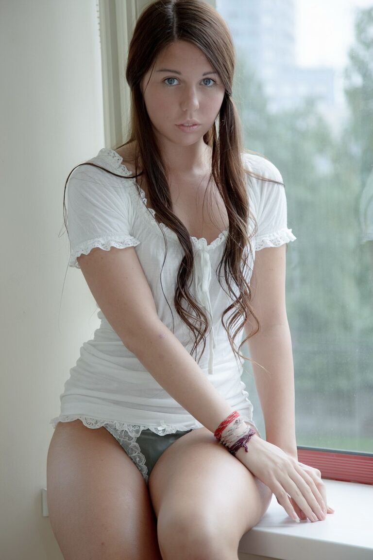 15P Girl next door type gets naked afore a window before toying her vagina