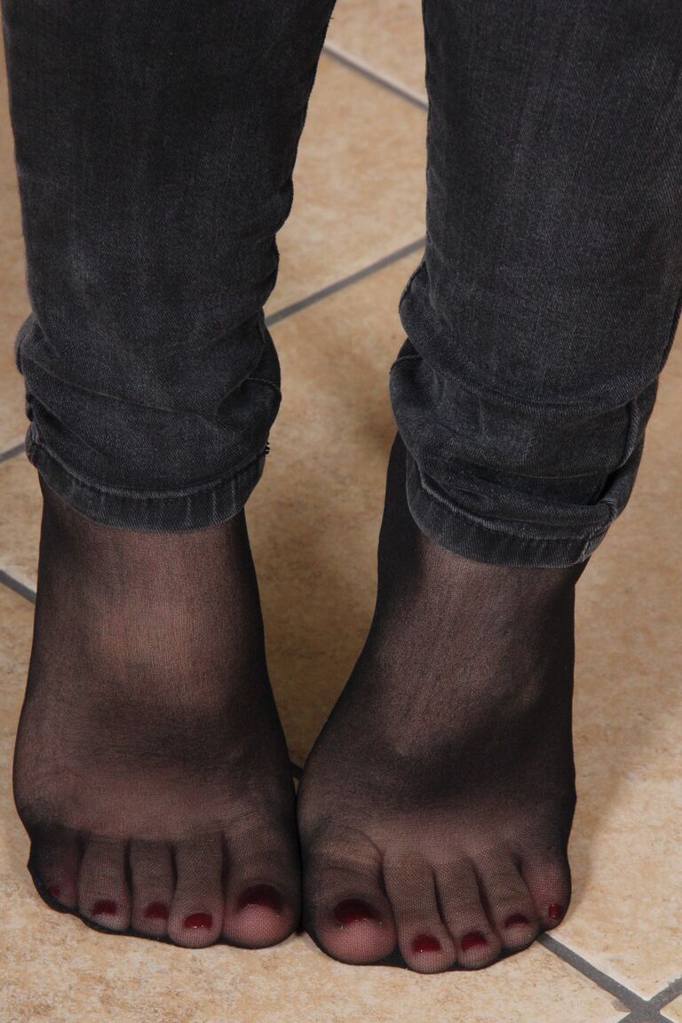 10P Garota sozinha com cabelo tingido libera os pés cobertos de meia-calça dos sapatos baixos
