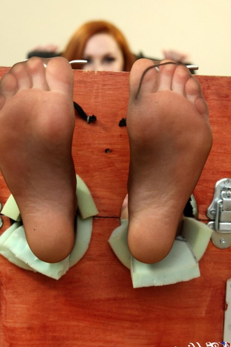 12P Natural redhead Sophie Nova removes her heels while her feet are in stocks