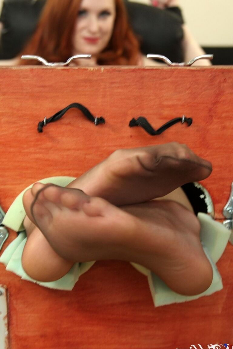 12P Natural redhead Sophie Nova removes her heels while her feet are in stocks