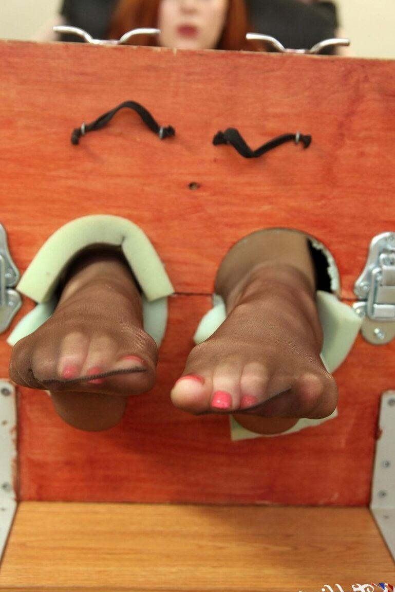 12P Natural redhead Sophie Nova removes her heels while her feet are in stocks