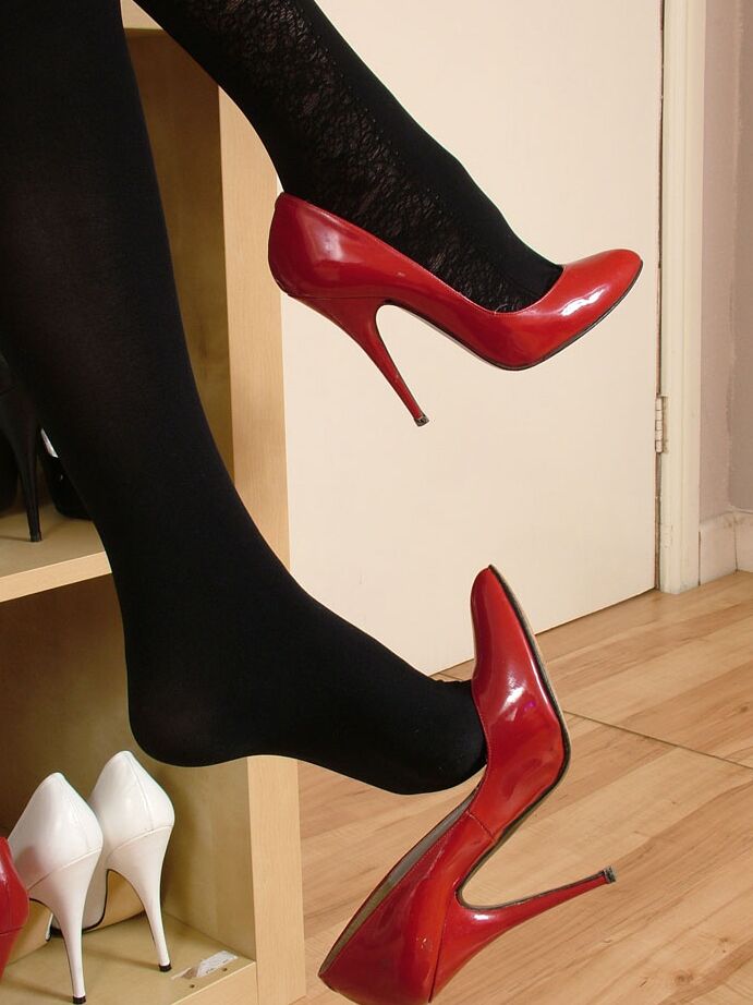 16P Fully clothed blonde dangles a red pump from stocking clad feet in a skirt