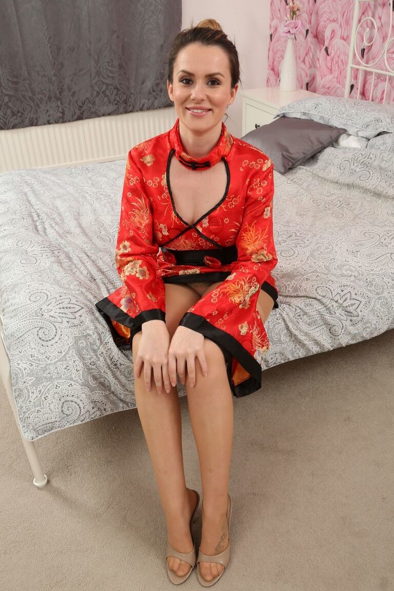 21P 微乳のブルネット、チャーリー・ローズが赤い服を脱いでトップレスでポーズをとる