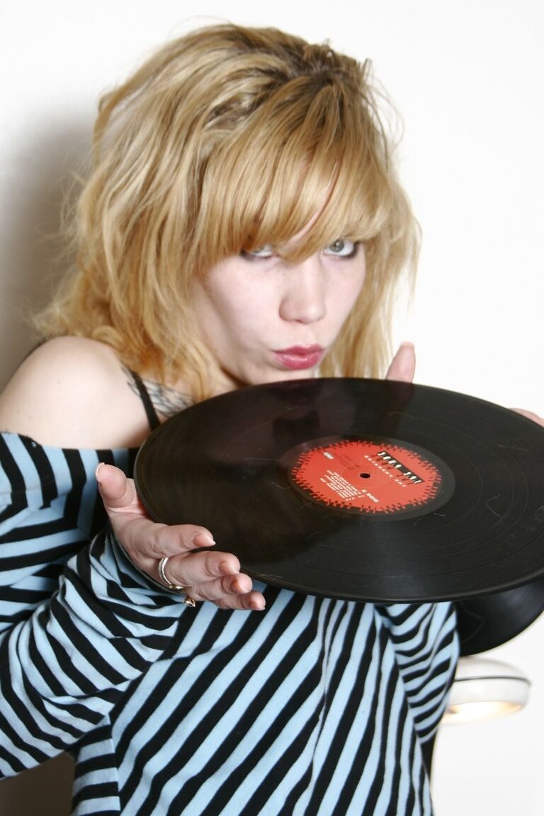 20P Joven coleccionista de discos se desnuda entre sus discos para posar en topless con medias