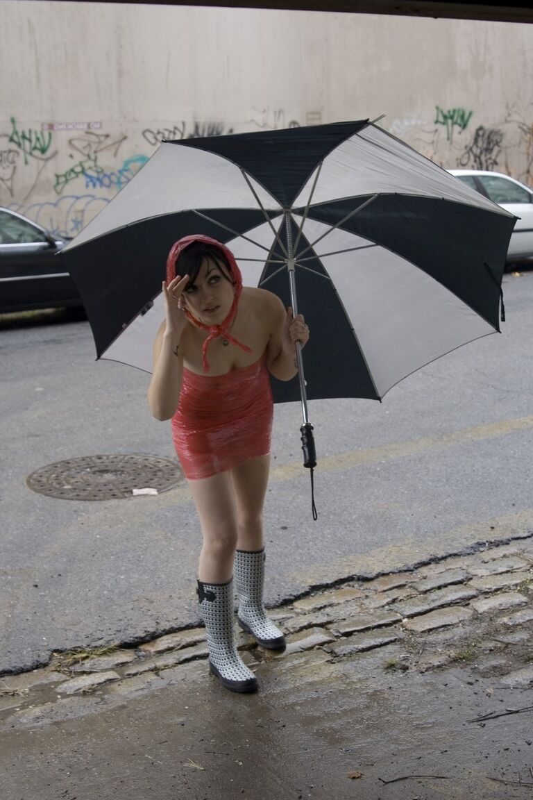 17P Adolescente totalmente mojada con piercings se quita el vestido de látex en un día lluvioso