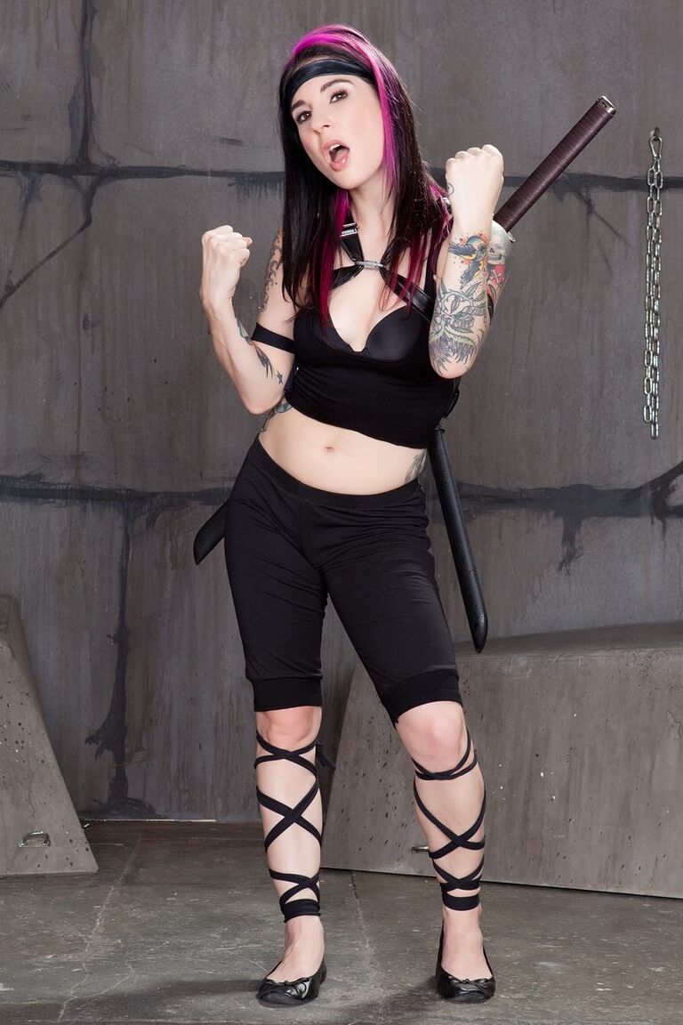 17P Tattooed Ninja with dyed hair holds a Samurai sword while disrobing
