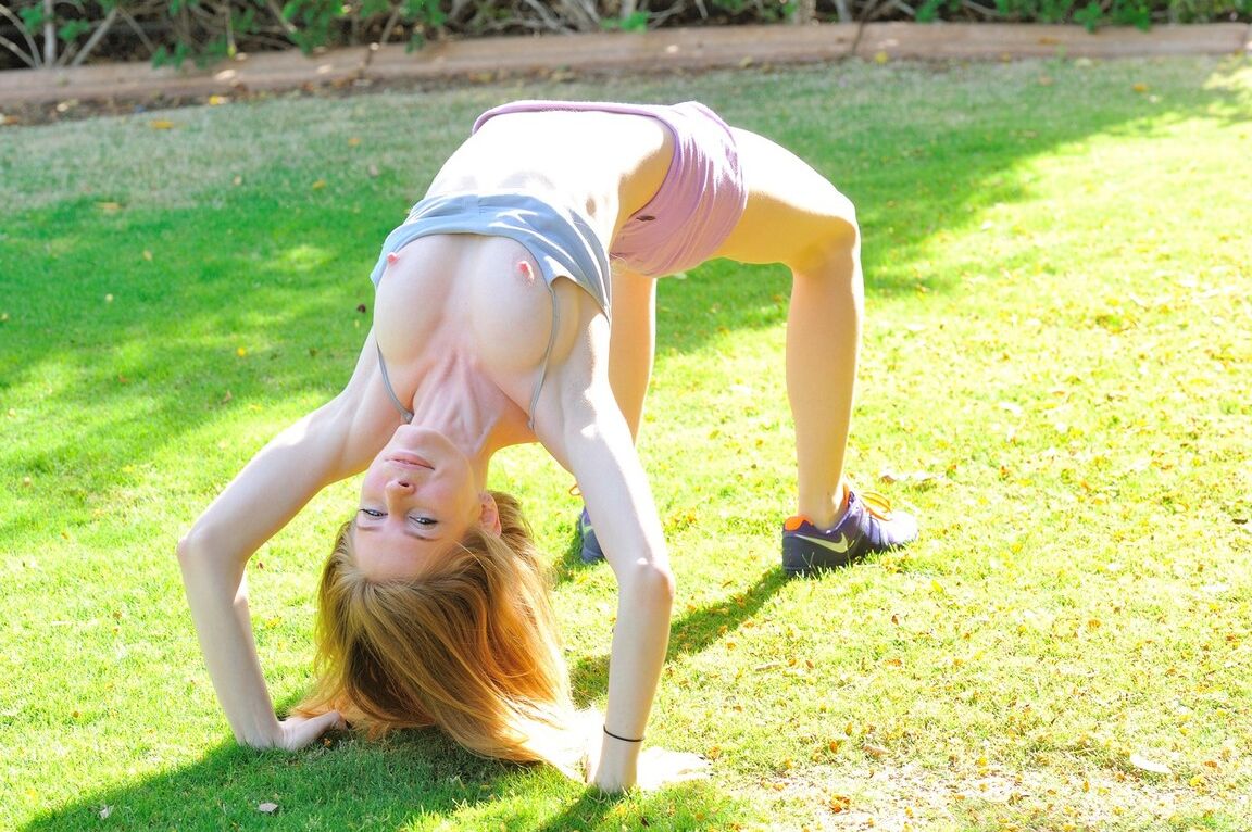 21P Redheaded babe Bethany fucks a huge dildo after stripping in the garden