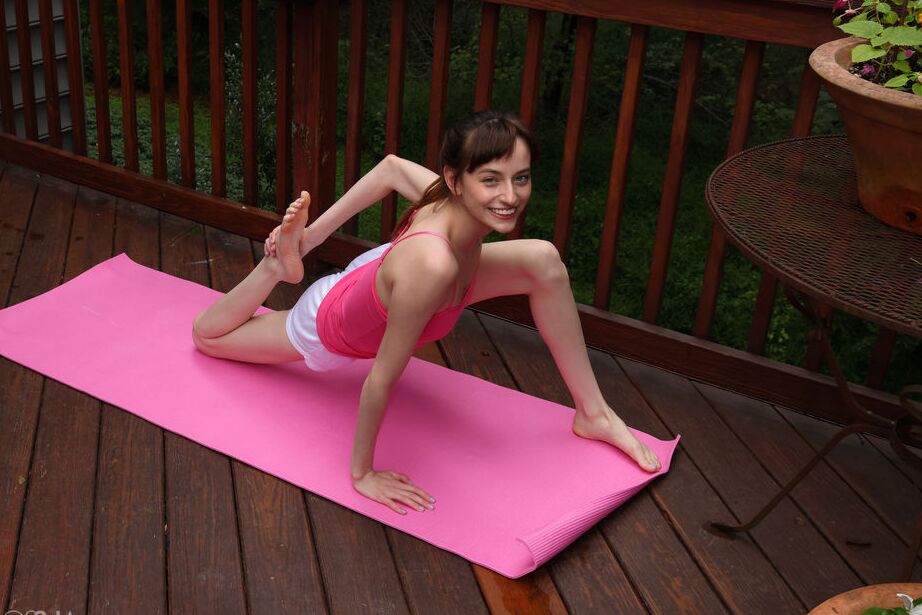 Das 16-jährige, flexible junge Mädchen Lana Smalls zieht sich beim Yoga auf einer Terrasse aus