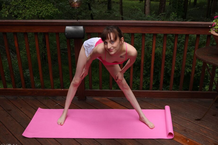 Das 16-jährige, flexible junge Mädchen Lana Smalls zieht sich beim Yoga auf einer Terrasse aus