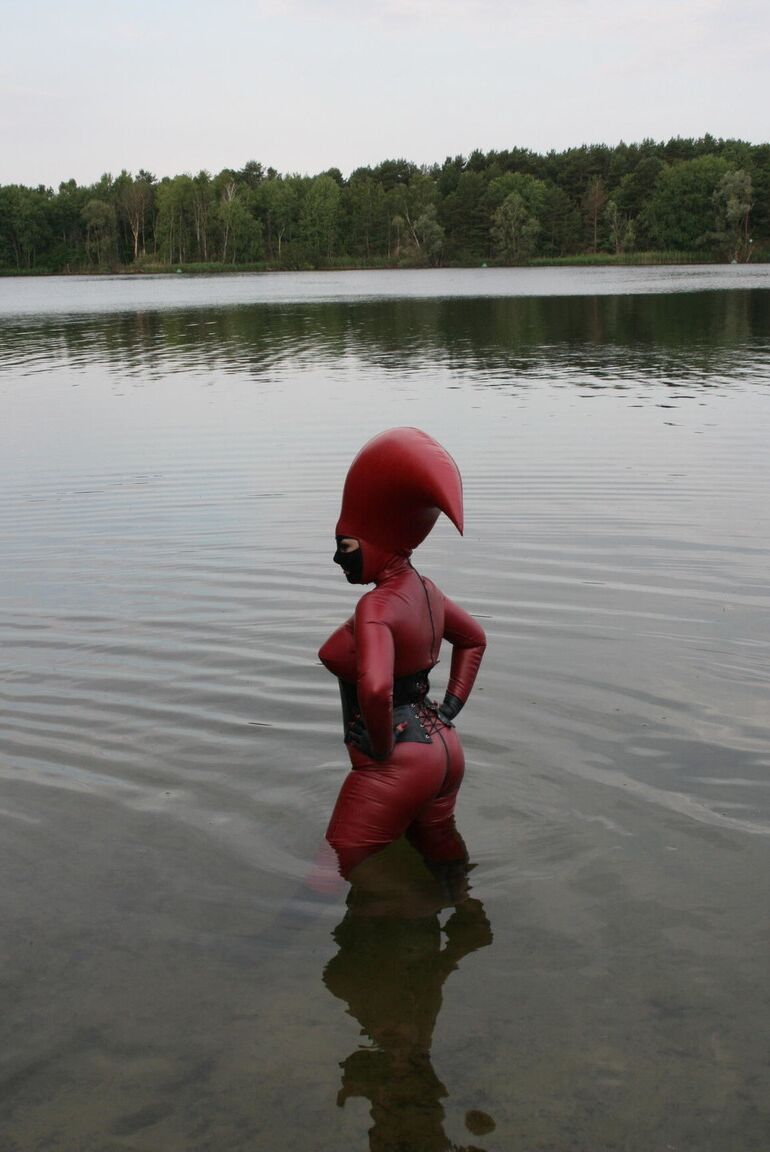 Le modèle fétichiste 16P Avengelique patauge dans un plan d'eau dans un costume en caoutchouc